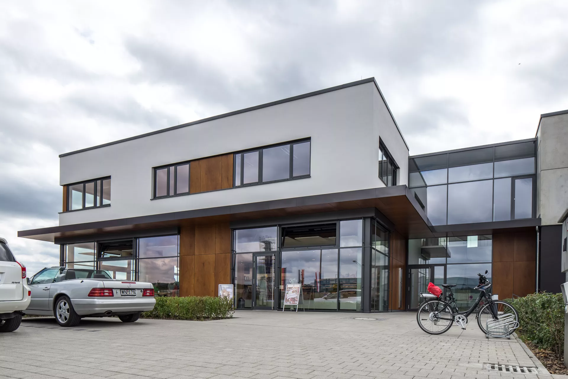 Außenansicht des Gebäudes mit dem gläsernen Eingang zur Bäckerei. 