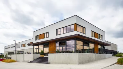 Außenansicht des 2-stöckigen modernen Gebäudes mit vielen Fenstern.