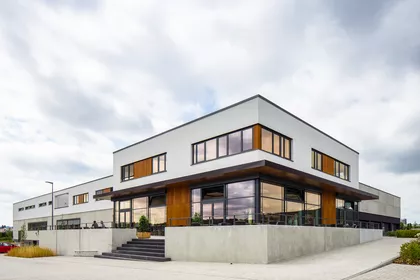 Außenansicht des 2-stöckigen modernen Gebäudes mit vielen Fenstern.